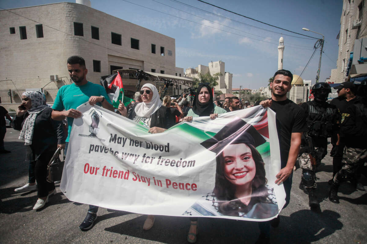 Palestinian activists lift a banner and portraits of slain Turkish-American International Solidarity Movement activist Aysenur Ezgi Eygi during a funeral procession in Nablus in the occupied West Bank, Palestine, on September 9, 2024.