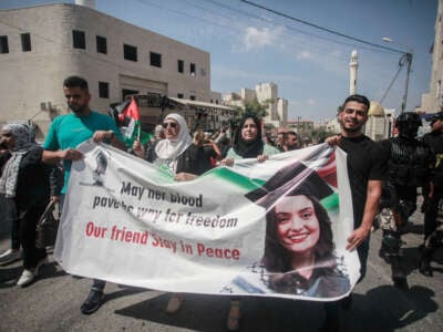 Palestinian activists lift a banner and portraits of slain Turkish-American International Solidarity Movement activist Aysenur Ezgi Eygi during a funeral procession in Nablus in the occupied West Bank, Palestine, on September 9, 2024.