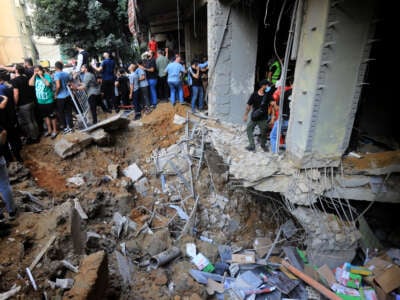 People gather near a crater caused by an Israeli air raid attack in a southern suburb of Beirut, Lebanon, on September 20, 2024.