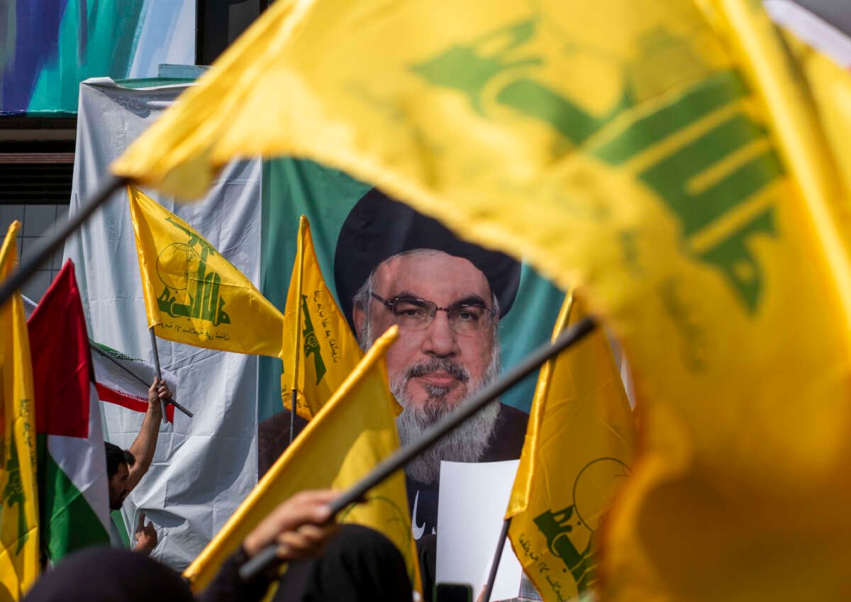 Iranians wave Lebanon's Hezbollah flags in front of a portrait of the Hezbollah Secretary General, Hassan Nasrallah, during a protest to condemn Israel's military attack on Lebanon, after Friday prayers ceremonies in downtown Tehran, Iran, on September 27, 2024.