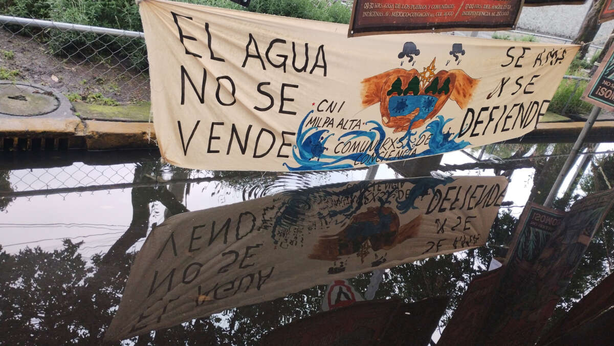 A banner reading "water isn't for sale ... it is loved and defended"