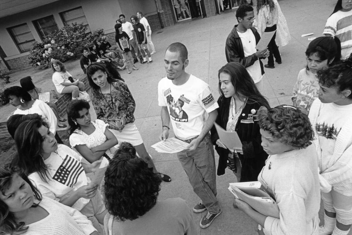 Keiko Lane and Cory Roberts-Auli pass out safe sex information at a high school.