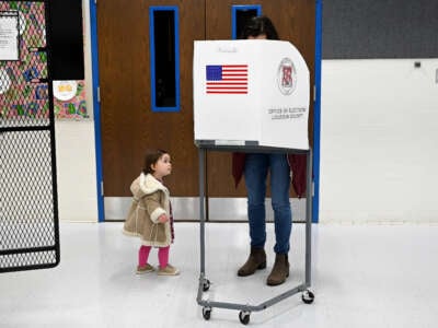 A child waits for her mother to vote at Evergreen Mills Elementary School on November 2, 2021, in Leesburg, Virginia.