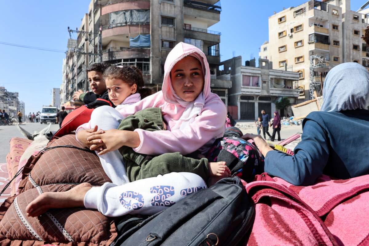 Palestinian children sit atop their family's belongings as they flee areas north of Gaza City in the northern Gaza Strip on October 12, 2024.