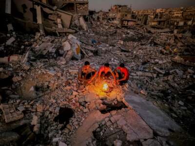 Palestinian boys light a fire over their destroyed house in the city of Khan Yunis, south of the Gaza Strip, on October 20, 2024, amid the ongoing war on Gaza.