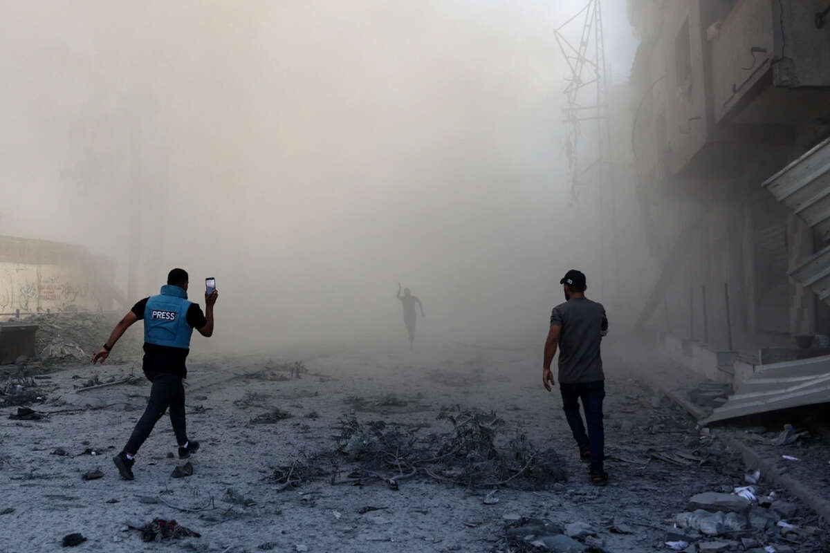 People and a journalist rush toward the scene of an explosion following an Israeli strike which reportedly targeted a school in the Zeitoun district on the outskirts of Gaza City, on September 1, 2024.