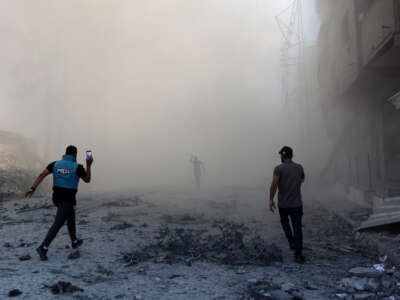 People and a journalist rush toward the scene of an explosion following an Israeli strike which reportedly targeted a school in the Zeitoun district on the outskirts of Gaza City, on September 1, 2024.