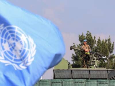 A member of the mine clearance team is pictured behind a UN flag during a tour by France's defence minister of the French contingent's United Nations Interim Forces in Lebanon (UNIFIL) base in the southern Lebanese village of Deir Kifa on November 2, 2023.