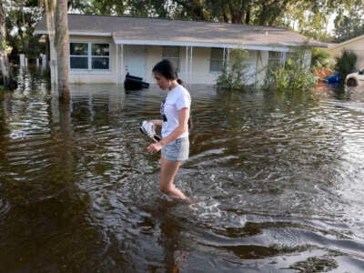 A person walks through a flooded road after Hurricane Helene passed offshore on September 27, 2024, in Crystal River, Florida.