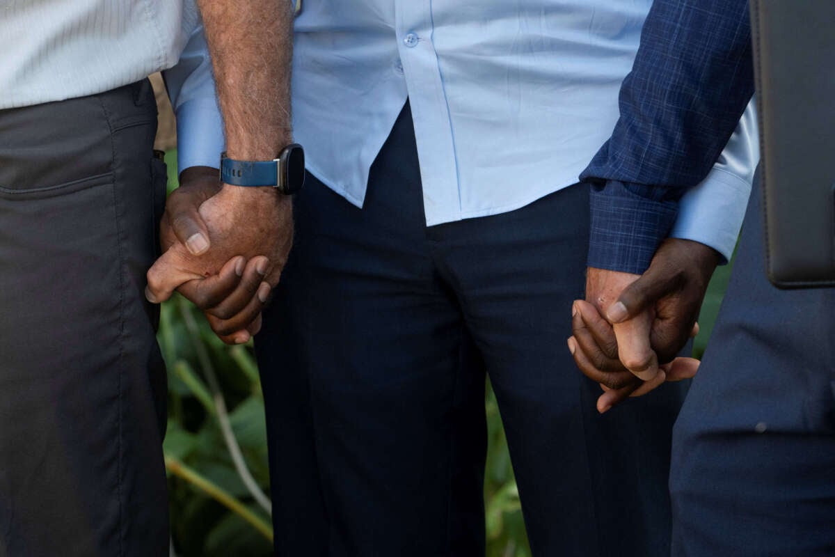 Vilés Dorsainvil (center), the executive director of the Haitian Community Help and Support Center, holds hands with pastors during a prayer at the end of a press conference where religious leaders called for calm and support following former President Donald Trump's racist and debunked rumors about Haitian immigrants, in Springfield, Ohio, on September 12, 2024.