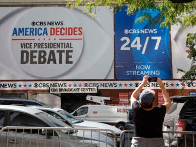 A woman takes pictures of the CBS Broadcast Center the day before the television network will host the vice presidential debate on September 30, 2024, in New York City.