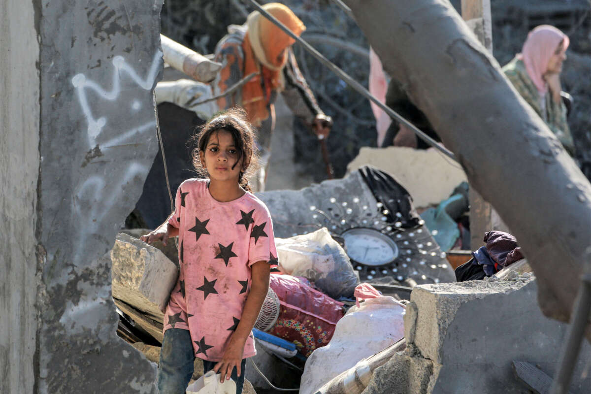 A child looks on while walking through the rubble of a collapsed building in Khan Yunis in the southern Gaza Strip on October 2, 2024.