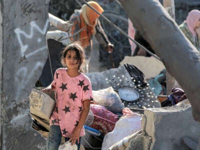 A child looks on while walking through the rubble of a collapsed building in Khan Yunis in the southern Gaza Strip on October 2, 2024.