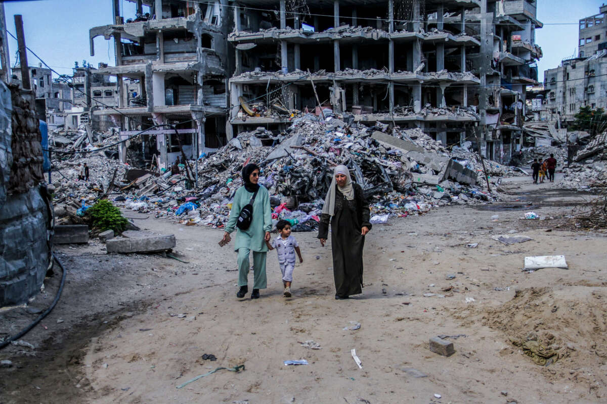 Palestinians walk past the damaged Al-Aliya Kindergarten, after it was bombed by an Israeli aircraft in Jabalia refugee camp, northern Gaza, on September 14, 2024.