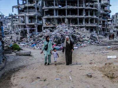 Palestinians walk past the damaged Al-Aliya Kindergarten, after it was bombed by an Israeli aircraft in Jabalia refugee camp, northern Gaza, on September 14, 2024.