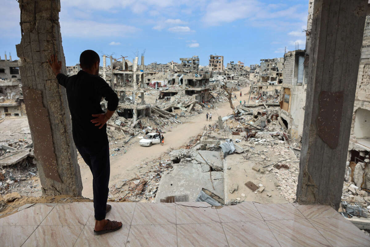 A Palestinian man looks from a damaged building at a dirt road lined with rubble in the Shujaiya neighbourhood of Gaza City on October 7, 2024, on the first anniversary of the ongoing war in the Gaza Strip between Israel and the Palestinian Hamas group.