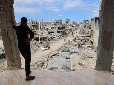 A Palestinian man looks from a damaged building at a dirt road lined with rubble in the Shujaiya neighbourhood of Gaza City on October 7, 2024, on the first anniversary of the ongoing war in the Gaza Strip between Israel and the Palestinian Hamas group.