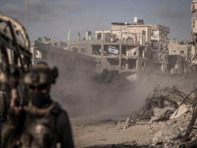 A photograph, taken during an embed with the Israeli military and reviewed by their censorship office prior to publication, shows Israeli military APC moving next to destroyed building amid the ongoing conflict between Israel and the Palestinian militant group Hamas.