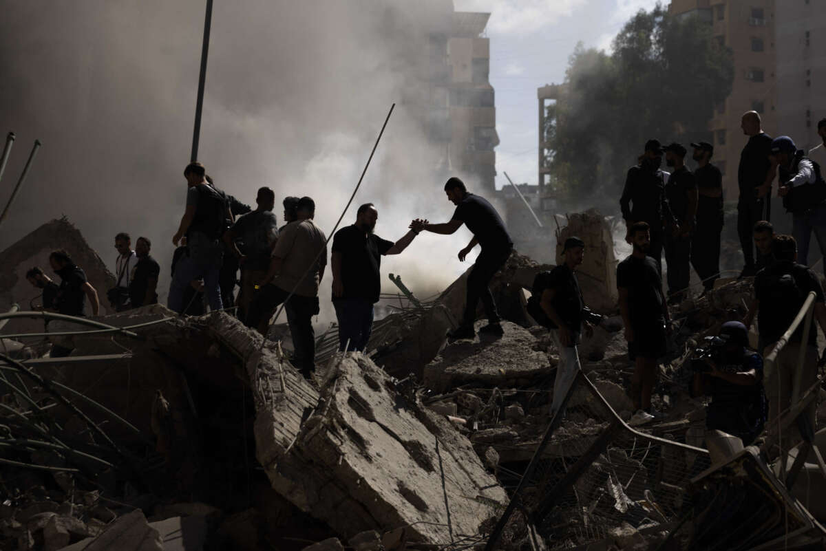 Smoke rises from a building destroyed by an Israeli airstrike as journalists and local residents visit during a press tour on October 2, 2024, in Beirut, Lebanon.