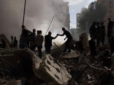 Smoke rises from a building destroyed by an Israeli airstrike as journalists and local residents visit during a press tour on October 2, 2024, in Beirut, Lebanon.