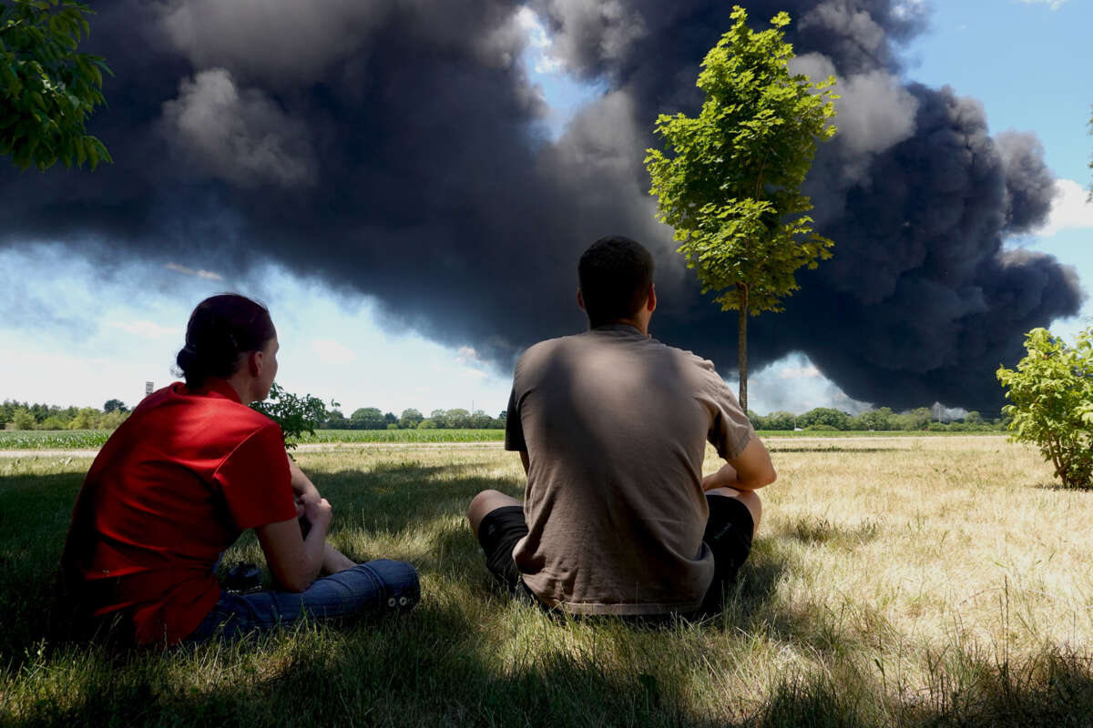 Jacques Ackerman and his wife Leigh Ackerman watch as an industrial fire burns at Chemtool Inc. on June 14, 2021, in Rockton, Illinois.