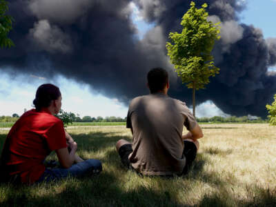 Jacques Ackerman and his wife Leigh Ackerman watch as an industrial fire burns at Chemtool Inc. on June 14, 2021, in Rockton, Illinois.