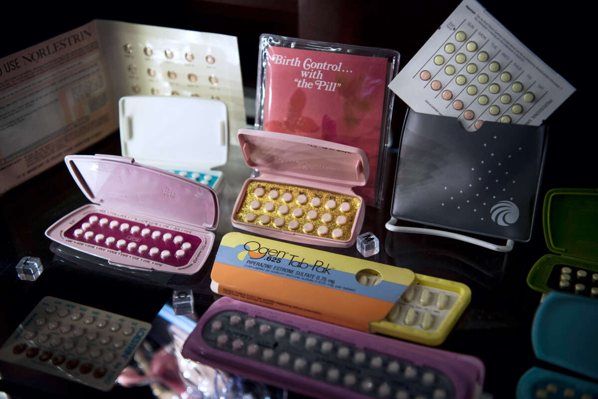 Various brands of birth control pills are displayed for a photo