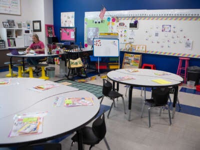 An educator sits in an empty classroom