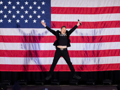 Elon Musk jumps in front of an oversized u.s. flag