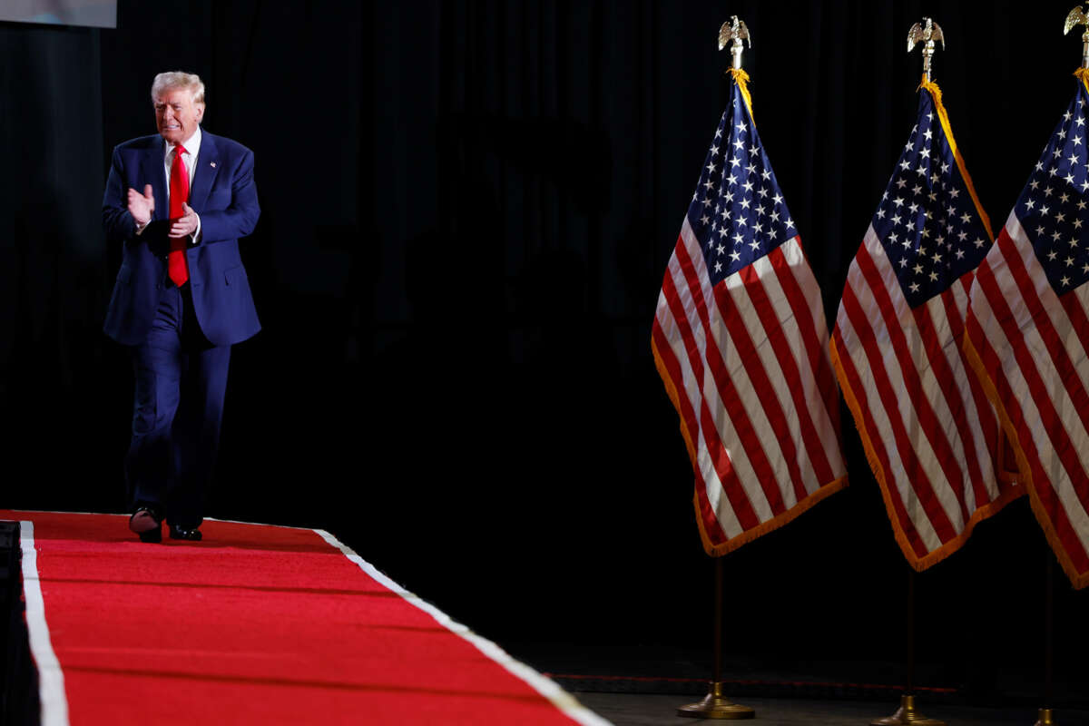 Donald Trump applauds himself as he walks onstage