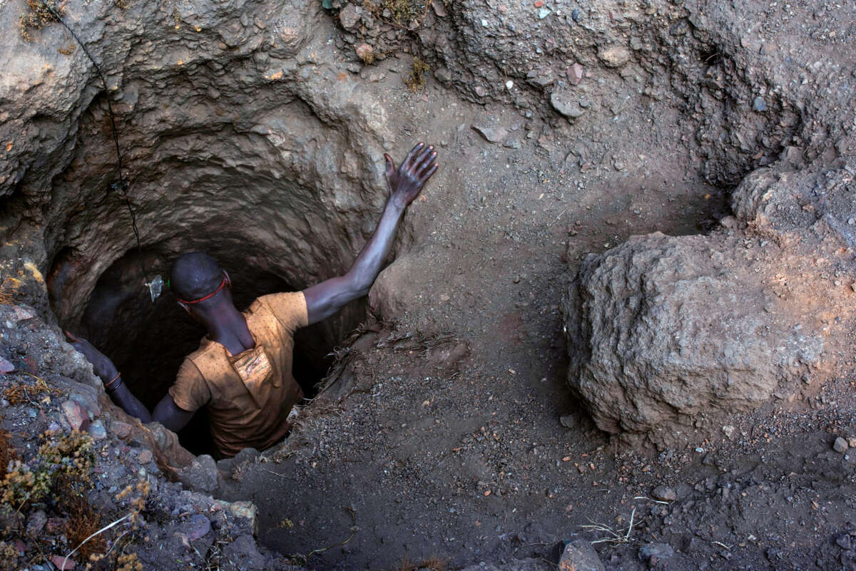 A man descends into a tiny hole in the ground