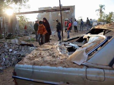 People inspect the damage at the site of an Israeli strike that targeted an area in Khan Yunis on the southern Gaza Strip on October 25, 2024.