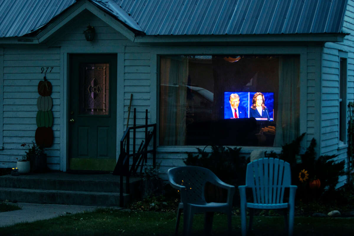 A television playing the U.S. presidential debate is seen through a residential home's window