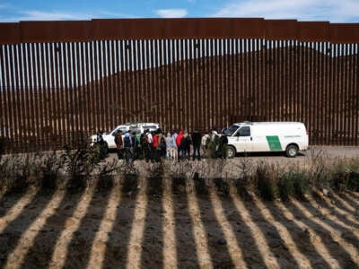 Border patrol agents talk to a group of migrant people, mostly from African countries, before processing them after crossing the U.S.-Mexico border, taken from Tijuana, Baja California state, Mexico, on November 11, 2022.