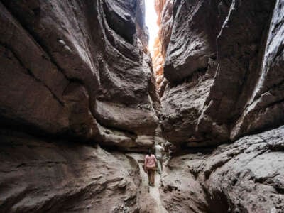 Sendy Hernández Orellana Barrows, conservation program manager for the Council of Mexican Federations (COFEM), and Colin Barrows, a member of the CactusToCloud Institute, hike through a slot canyon in the the Ladder Canyon trail at Painted Canyon located in the Mecca Hills Wilderness near Mecca on October 13, 2022. Local organizations are working together to establish a new national monument in the Chuckwalla Valley, south of Joshua Tree National Park. The proposed Chuckwalla National Monument would protect important historical lands, cultural resources and biodiverse species.