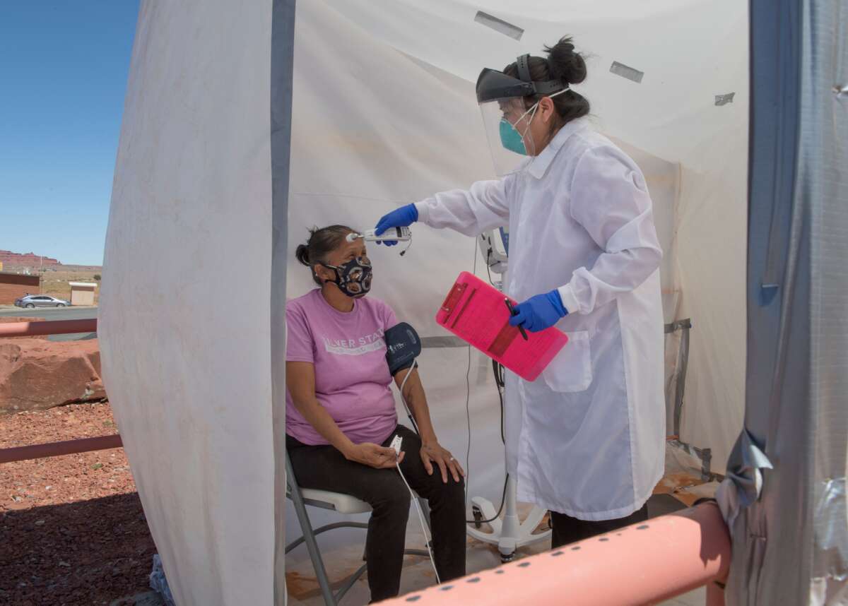 A nurse checks vitals from a Navajo Indian woman complaining of virus symptoms, at a COVID-19 testing center at the Navajo Nation town of Monument Valley in Arizona on May 21, 2020.