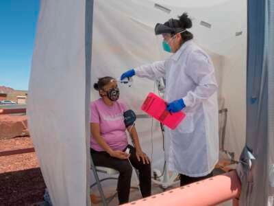 A nurse checks vitals from a Navajo Indian woman complaining of virus symptoms, at a COVID-19 testing center at the Navajo Nation town of Monument Valley in Arizona on May 21, 2020.