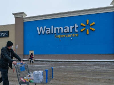 A man pushes a cart in front of a Walmart store on January 12, 2021, in Edmonton, Alberta, Canada.