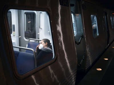 A passenger wears a mask while riding a train passing through the Metro Center station on January 4, 2024, in Washington, D.C.