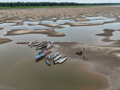 River dwellers use a motorized tricycle to transport food and passengers along the dry bed of the Solimões River in Manacapuru, Amazonas State, northern Brazil, on September 30, 2024.