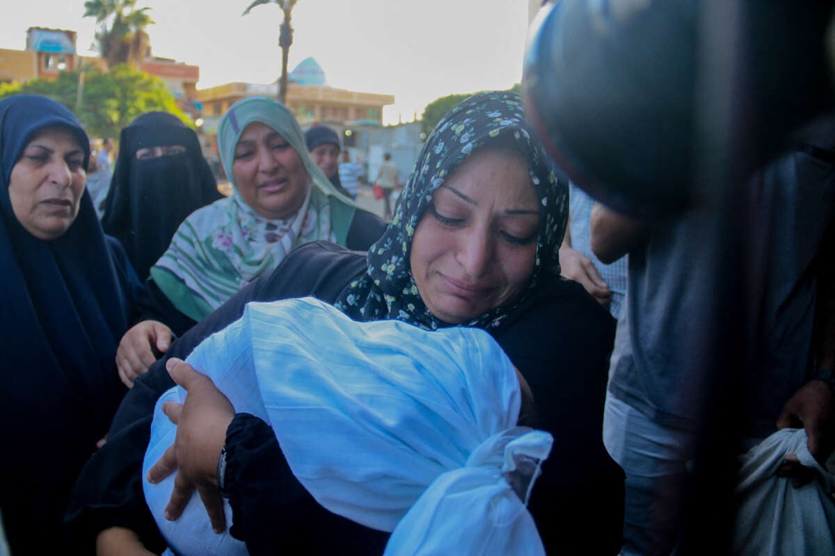 A Palestinian woman kisses a child who was killed in an Israeli strike outside Al-Aqsa Martyrs Hospital in Deir Al-Balah in the central Gaza Strip, on October 9, 2024.