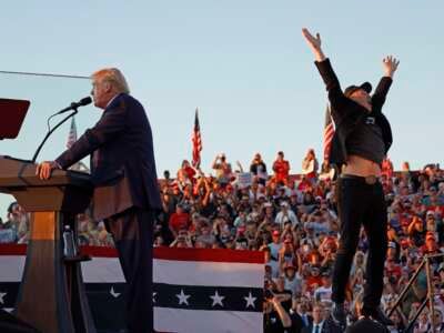 Elon Musk leaps on stage with Republican presidential nominee Donald Trump during a campaign rally on October 5, 2024, in Butler, Pennsylvania.