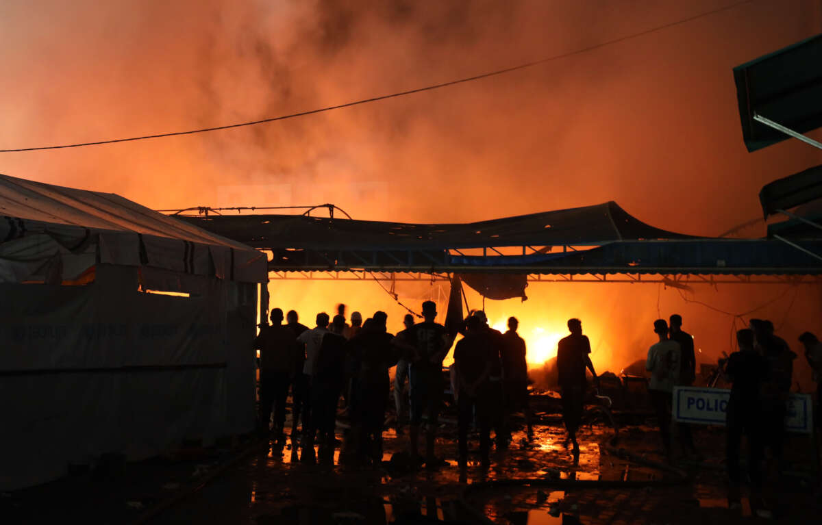 People attempt to extinguish a fire following an Israeli strike on tents sheltering displaced people in Deir el-Balah, Gaza, on October 14, 2024.