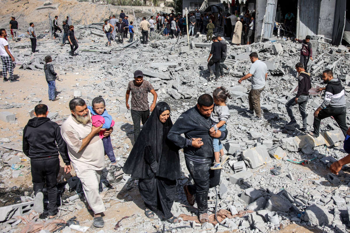 People exit through rubble following Israeli bombardment on the four-story Muqat family house in the Zarqa neighborhood in the north of Gaza City, on October 26, 2024.