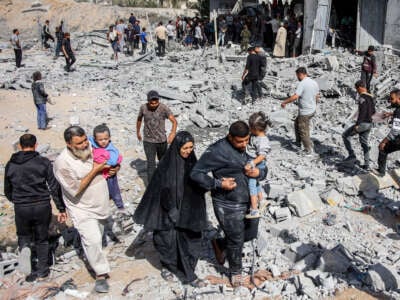 People exit through rubble following Israeli bombardment on the four-story Muqat family house in the Zarqa neighborhood in the north of Gaza City, on October 26, 2024.