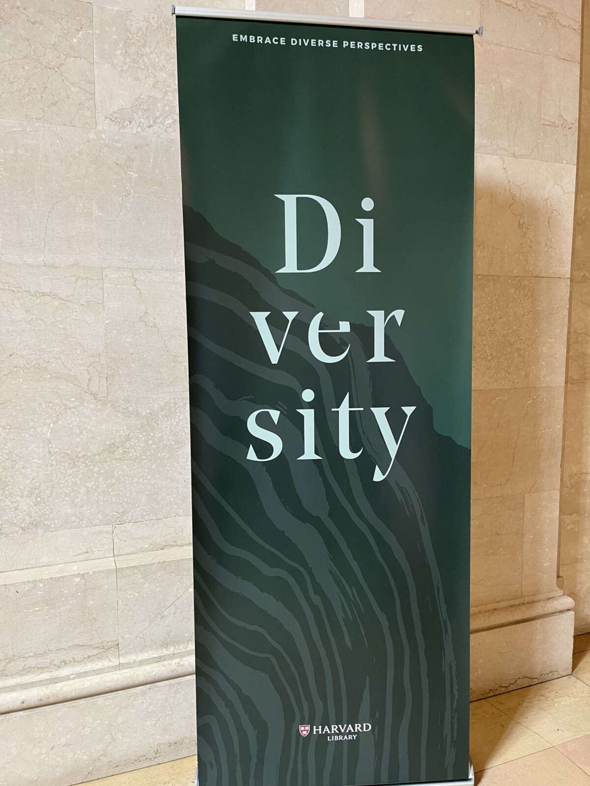 A banner outside the Harvard Library reading room where Harvard professors sat quietly reading with signs quoting the banner’s encouragement to “embrace diverse perspectives.”