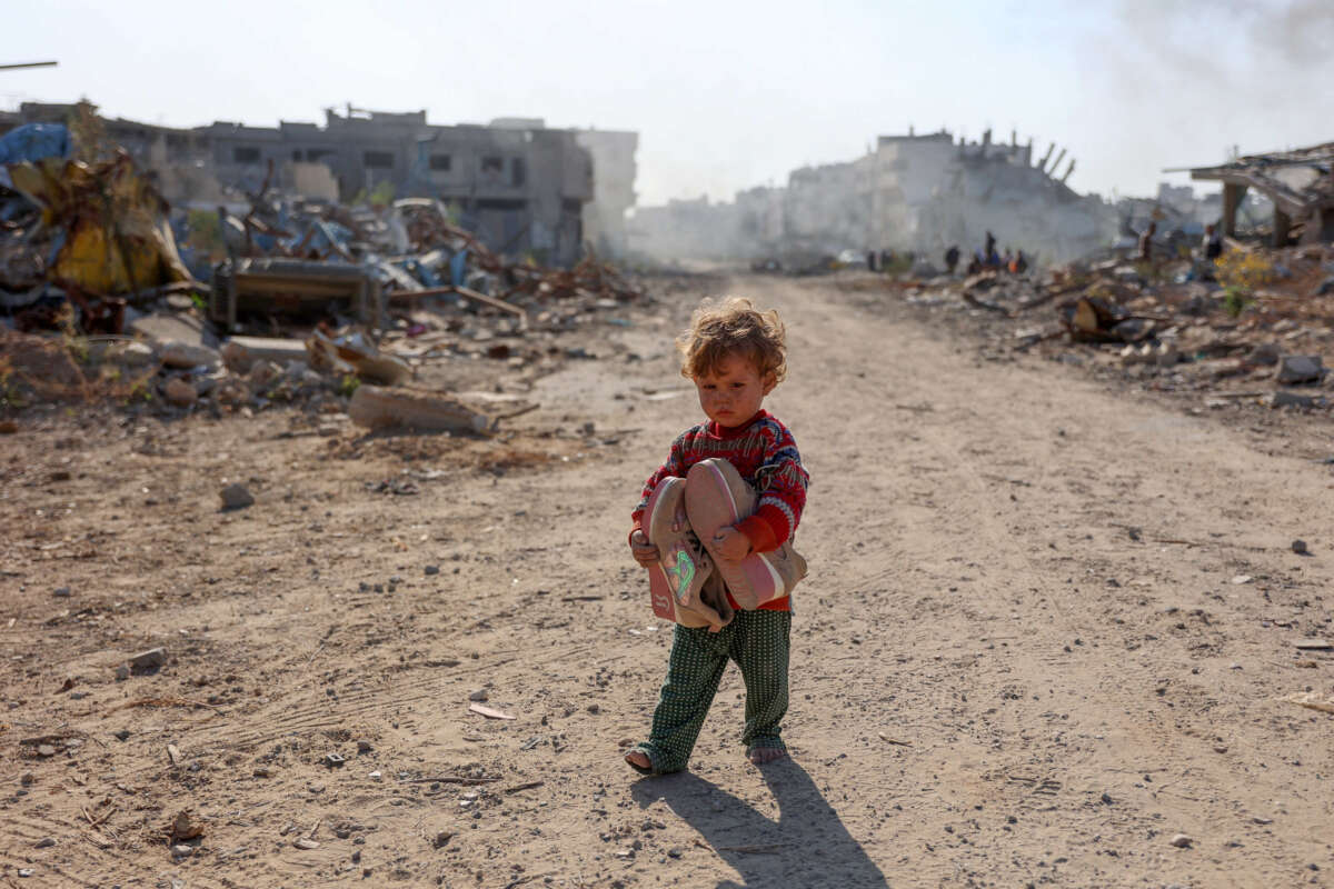 A displaced Palestinian child fleeing Beit Lahia in the northern Gaza Strip, walks on Gaza's main Salah al-Din road on the outskirts of Gaza City, on November 5, 2024.