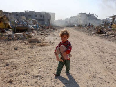 A displaced Palestinian child fleeing Beit Lahia in the northern Gaza Strip, walks on Gaza's main Salah al-Din road on the outskirts of Gaza City, on November 5, 2024.