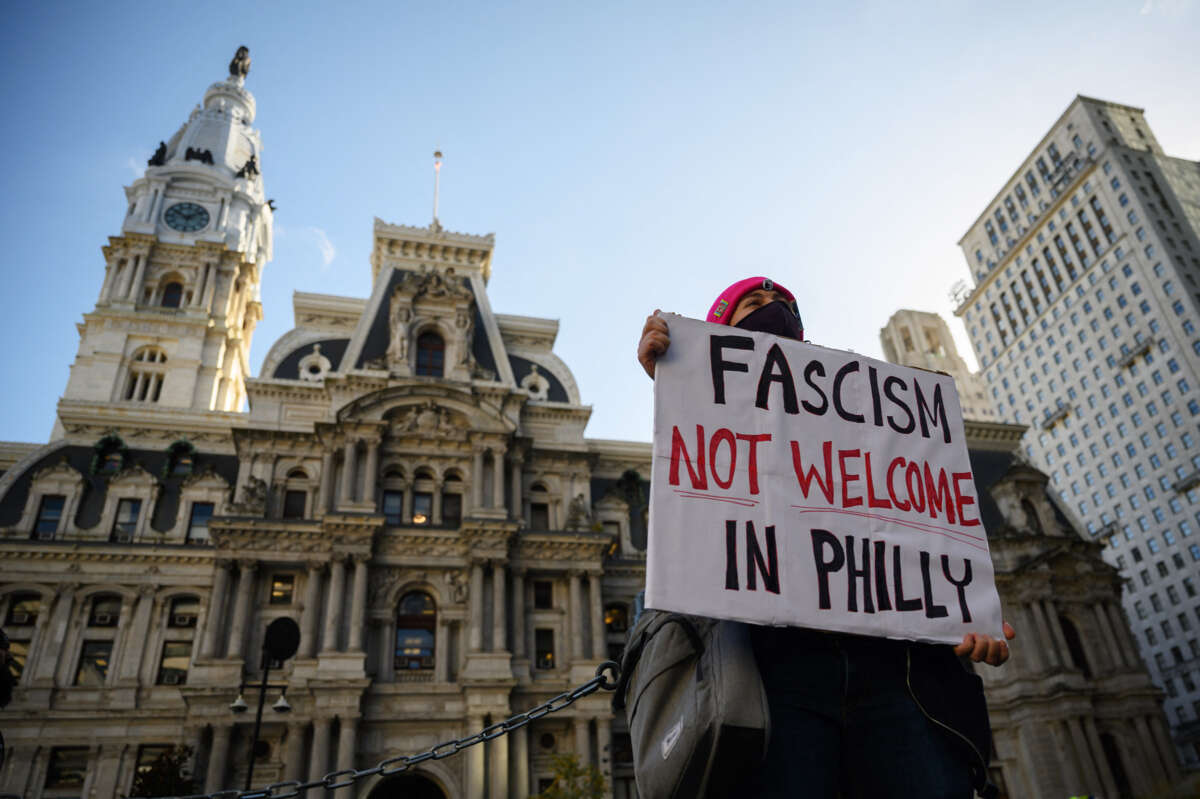 A protester holds a sign reading "FASCISM NOT WELCOME IN PHILLY"