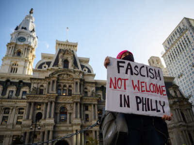 A protester holds a sign reading "FASCISM NOT WELCOME IN PHILLY"